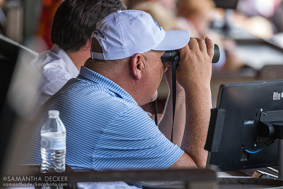 Kenny McPeek looks out to the track through binoculars from his box