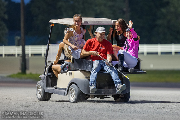 Katie Davis waves from a golf cart