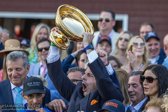 Mike Repole holds up the Travers trophy